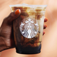 Hand holding Iced Brown Sugar Oatmilk Shaken Espresso
